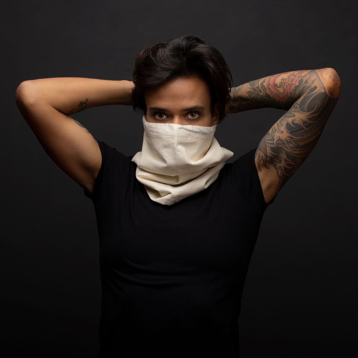 Woman with hands up behind head with a natural hemp and cotton Biogaiter pulled up over her face 