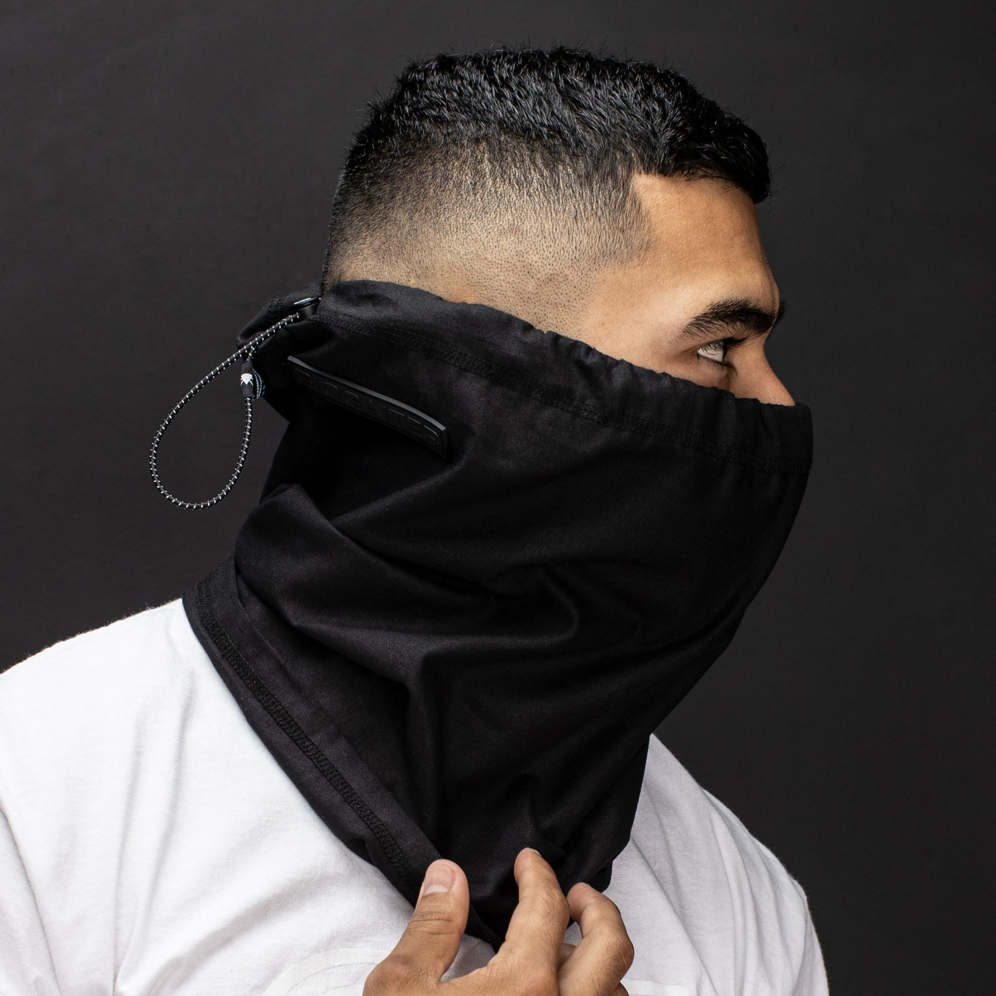 Profile of young man looking to the side with a black hemp and cotton biogaiter 